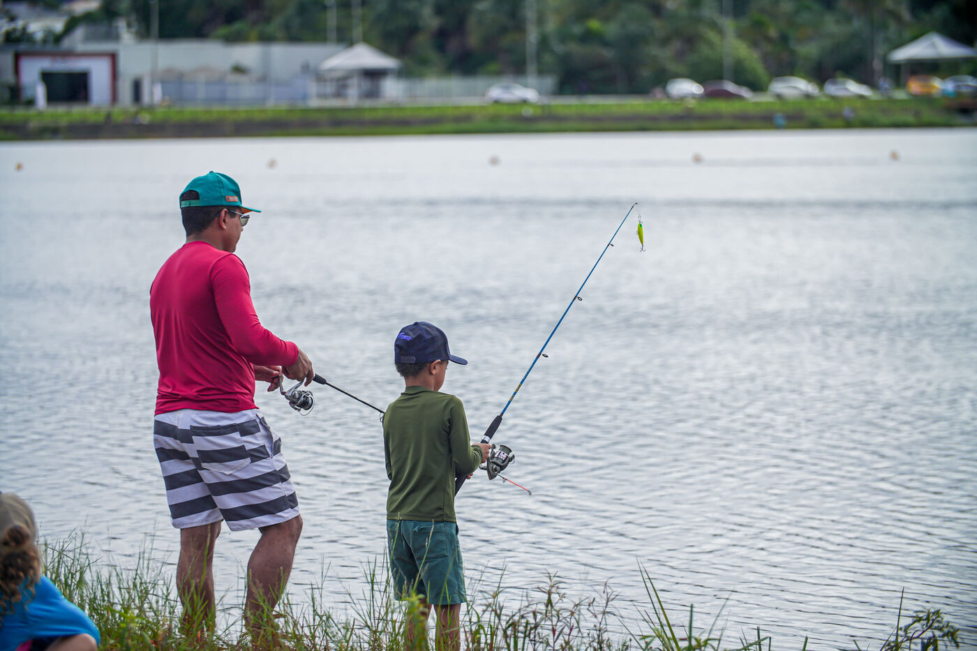 Pai e filho pescando juntos na beira do lago